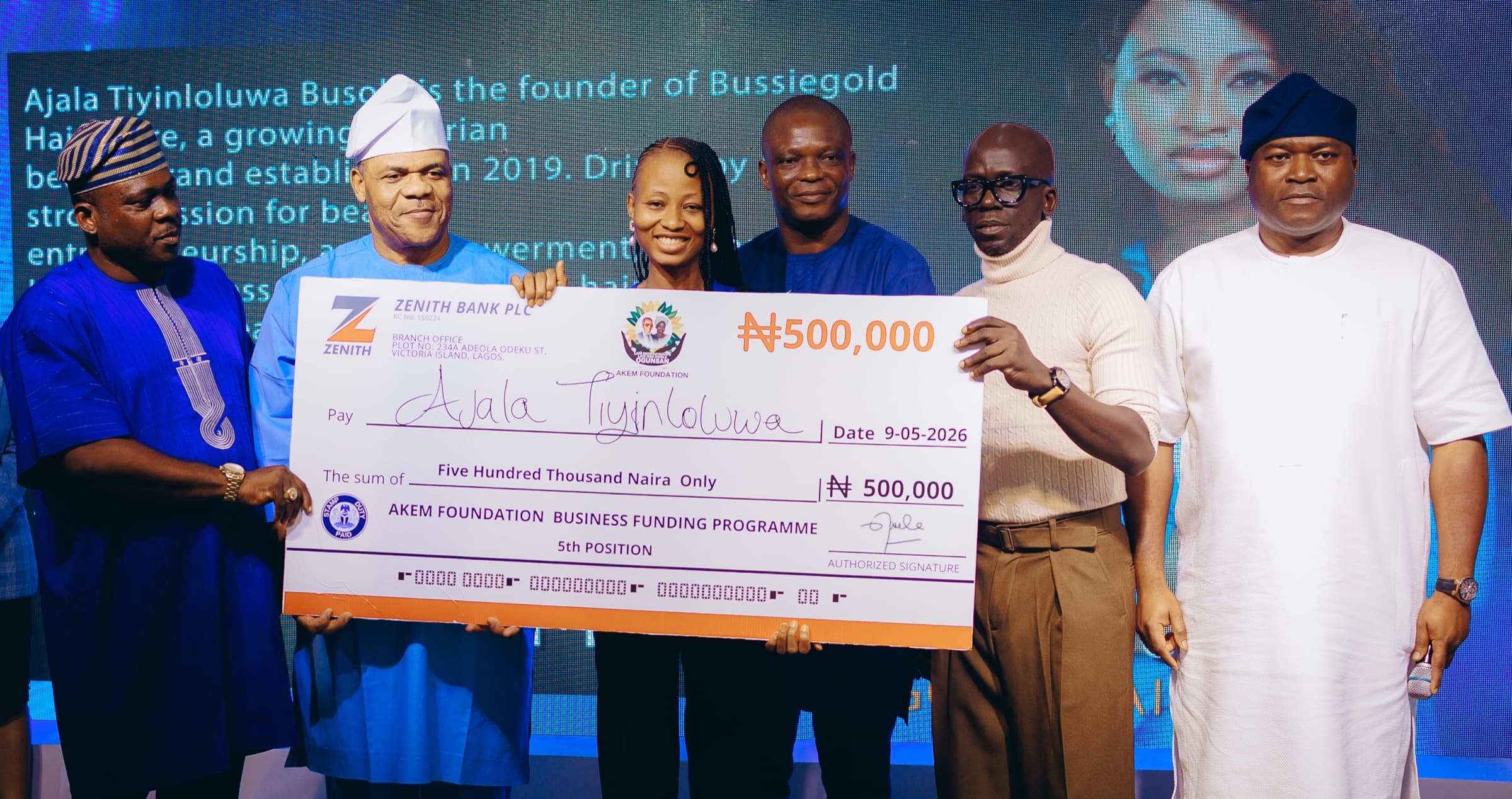 Ajala Tiyinloluwa receiving an AKEM Foundation business grant