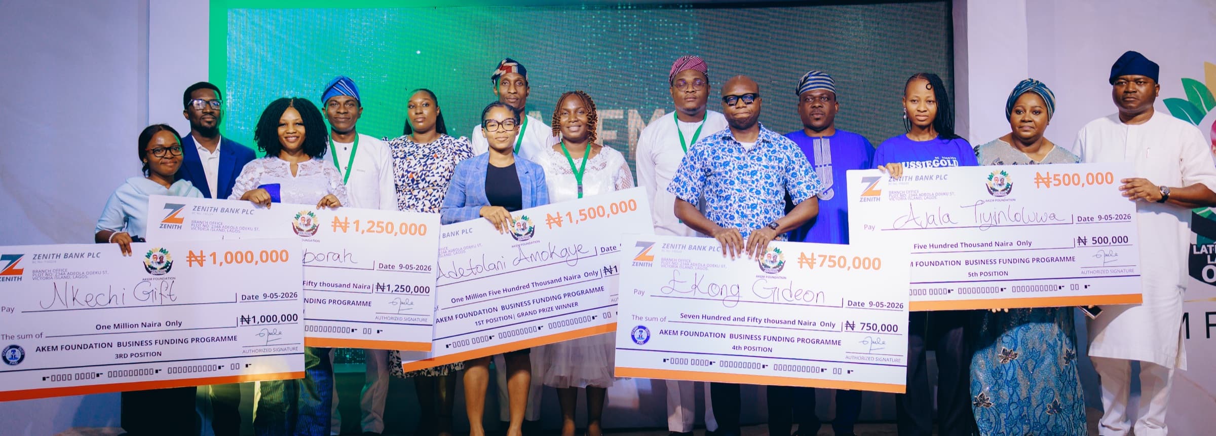 The five 2026 grant recipients holding their cheques on stage with Dr. Ogunsan
