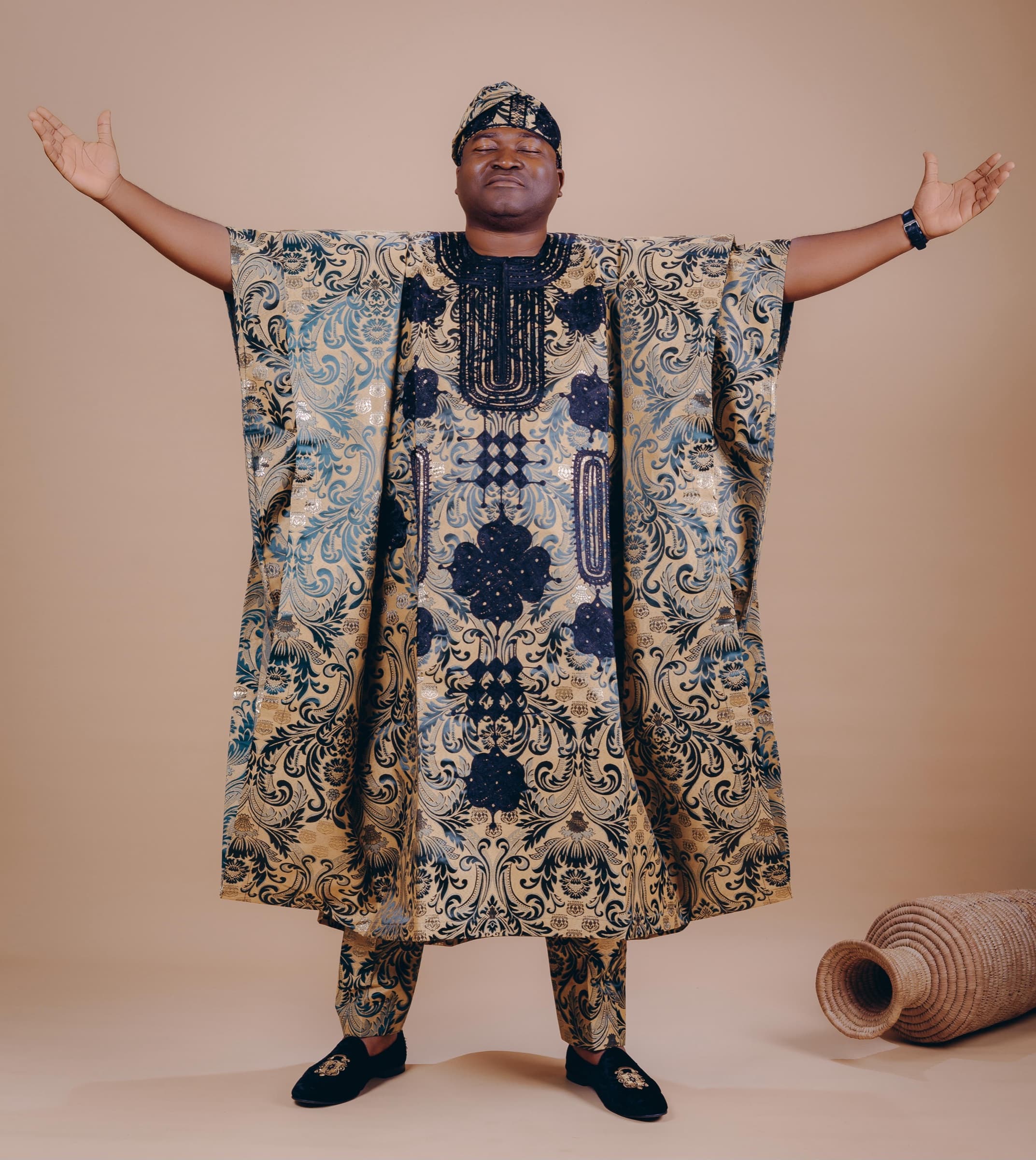 Dr. Ogunsan in a patterned agbada with his arms open