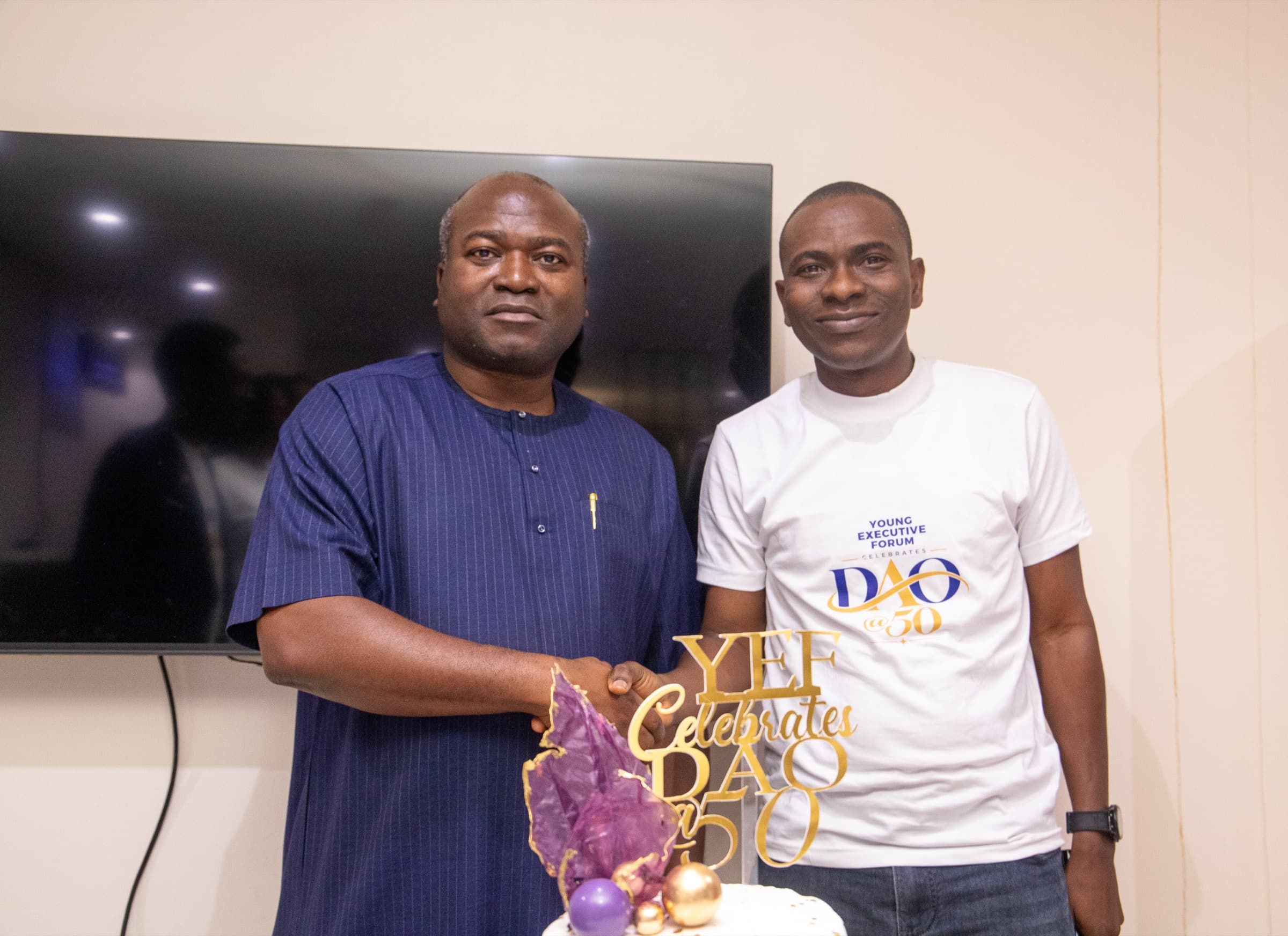 Dr. Ogunsan shaking hands with a forum member over the birthday cake